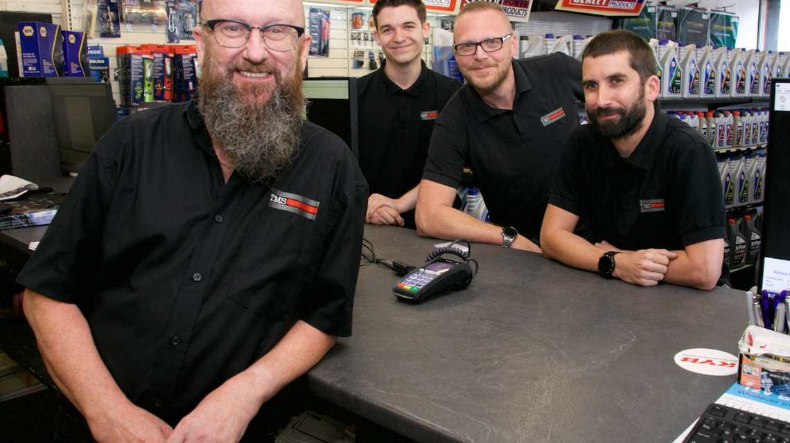 Counter team smiling and leaning over the counter
